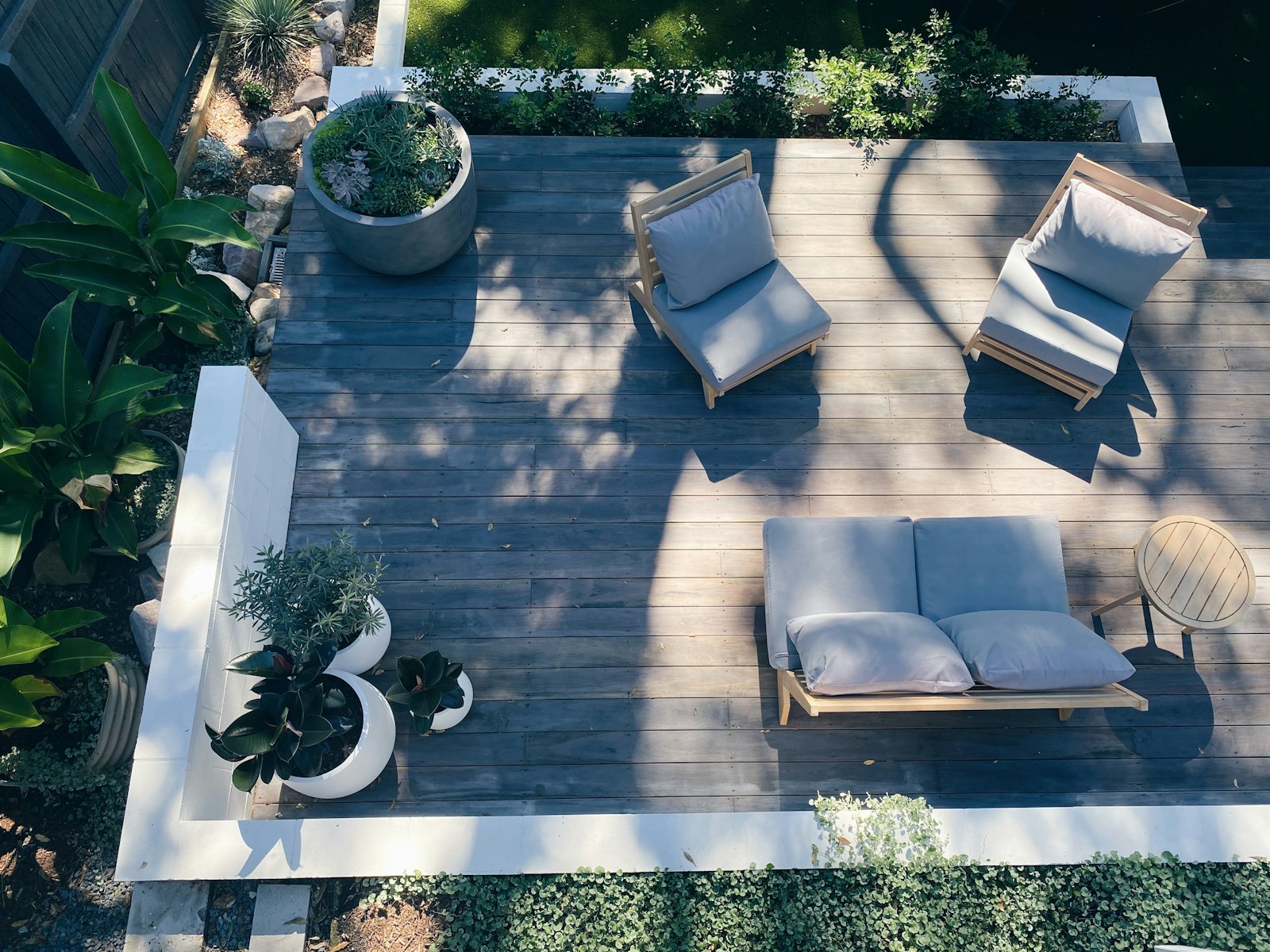Terrasse en bois vue du dessus, salon d'extérieur et jardinières